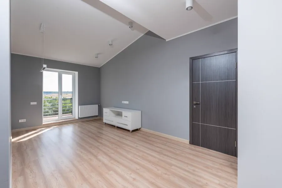 Bright, immaculately clean open-plan room with hardwood floors