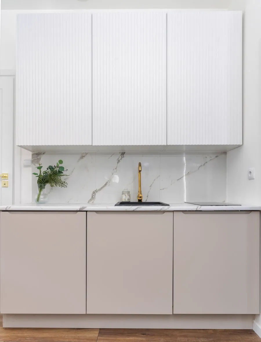 Luxurious remodeled kitchen with marble backsplash and gold fixtures